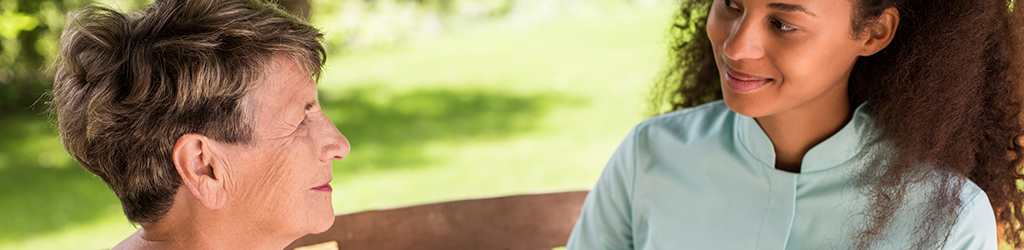 A community health worker meets with an older female patient.