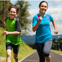 adolescent children running for exercise on an outdoor pathway.