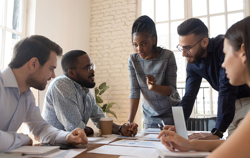 Corporate business team discuss paperwork at a group briefing