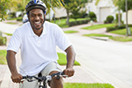 Man riding a bike while wearing a helmet represents interventions to increase physical activity.