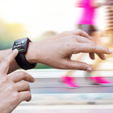 A runner checks his heart rate using a smartwatch.