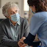 A nurse talks to an older female patient.