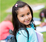 A young girl wearing a backpack and carrying a folder of papers.