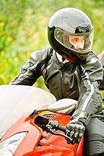 Man on motorcycle, wearing helmet represents universal helmet laws to prevent motor vehicle deaths and injuries.