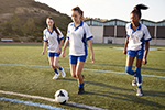 Three girls practice soccer.